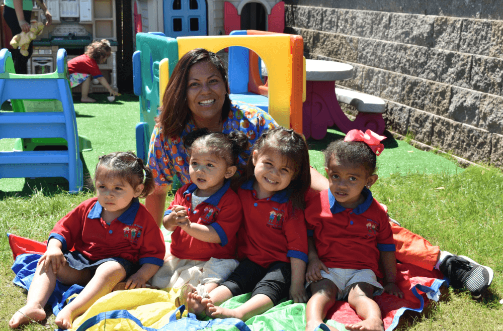 Child Care Educator with group of children all our kin