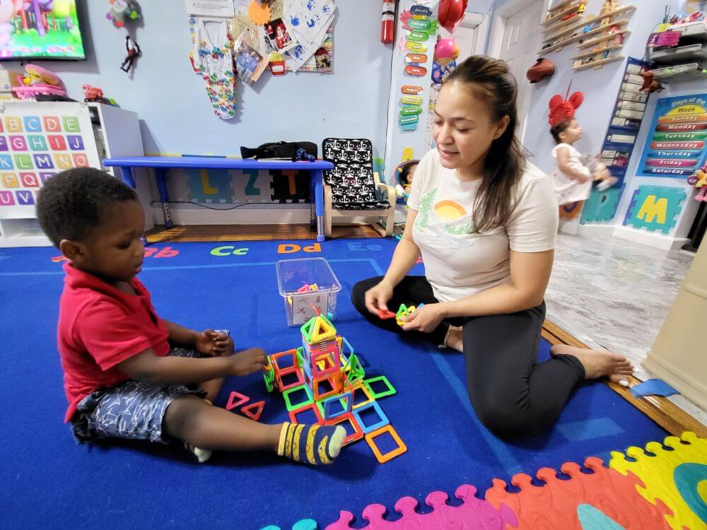 child care educator with child on mat